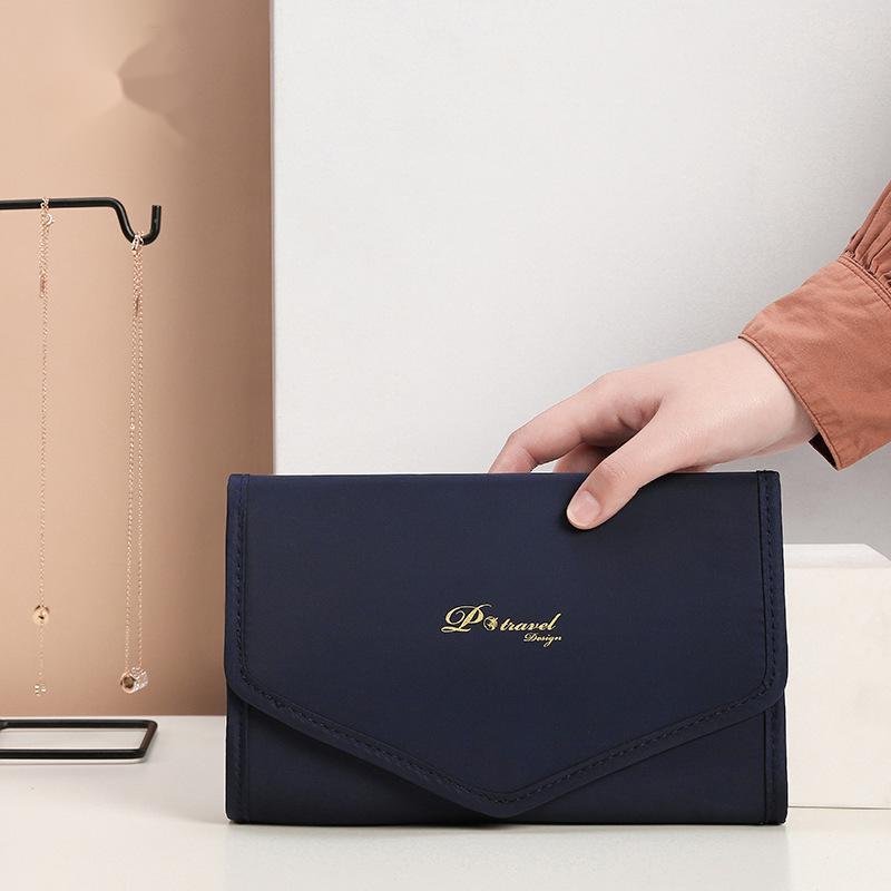 Elegant and portable navy blue travel jewelry bag with multiple compartments for organizing rings, necklaces, and earrings.