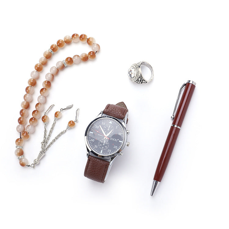 A chic boutique gift set featuring a stylish watch, a rosary, a ring, and a sleek pen, all presented in elegant black and brown color options.