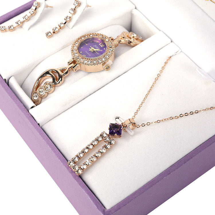 Ladies Jewelry Set featuring alloy material with diamond processing, including earrings, item decorations, hand decorations, and a bamboo link chain with a pendant. Available in red and purple colors, packed individually. Dimensions: 13.5 * 10.5 * 7 cm.