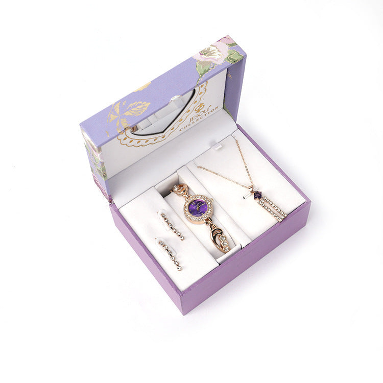 Ladies Jewelry Set featuring alloy material with diamond processing, including earrings, item decorations, hand decorations, and a bamboo link chain with a pendant. Available in red and purple colors, packed individually. Dimensions: 13.5 * 10.5 * 7 cm.