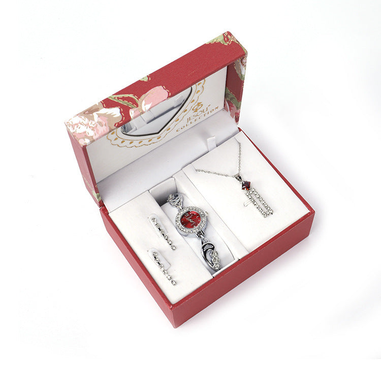 Ladies Jewelry Set featuring alloy material with diamond processing, including earrings, item decorations, hand decorations, and a bamboo link chain with a pendant. Available in red and purple colors, packed individually. Dimensions: 13.5 * 10.5 * 7 cm.