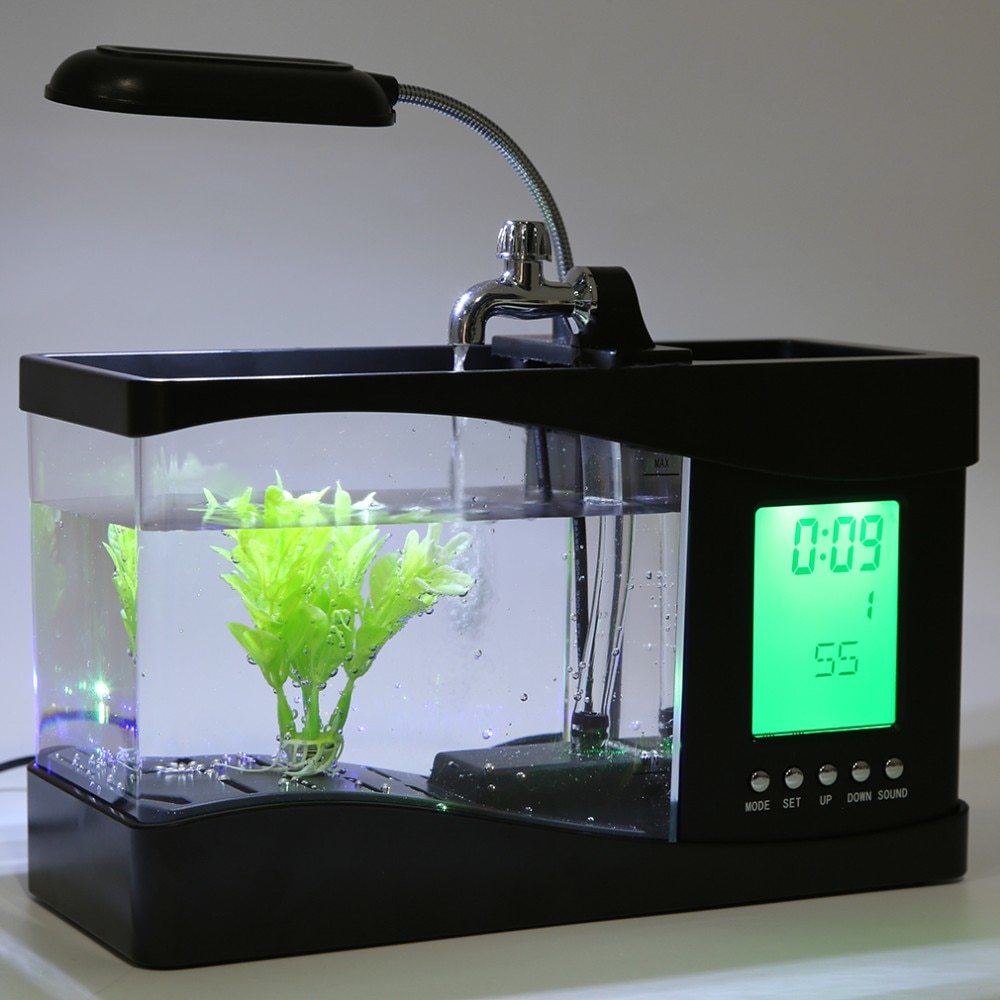 "Mini Aquarium Office Desk Organizer β A multifunctional desk accessory featuring an aquarium, LED table lamp, calendar, alarm, and pen holder, complete with small pebbles and a plant, creating a calming workspace atmosphere."