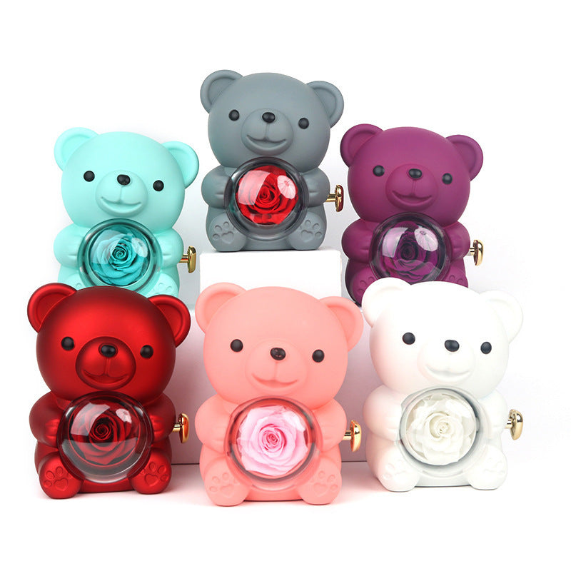 **Rotating Bear Gift Box β Playful & Elegant Packaging π** A **plastic jewelry box** with a **rotating bear design** and **preserved plastic flowers**, perfect for gifting jewelry. Measures **12x13x15.5cm**. Adds charm to your special present! π