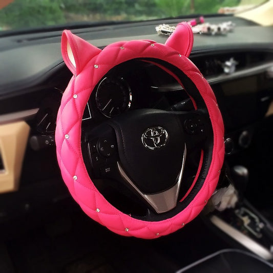 Super cute steering wheel cover made from environmentally friendly PU leather, embellished with high-quality rhinestones and a playful ear design. Suitable for all seasons and most steering wheels.