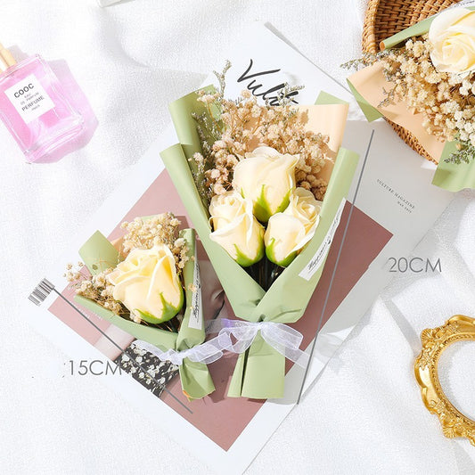 **"Elegant soap flower bouquet featuring delicate roses, forget-me-nots, and carnations, beautifully wrapped in premium paper with a gold ribbon. A timeless gift for weddings, birthdays, and special occasions."**