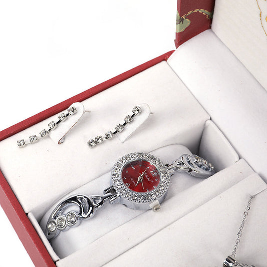 Ladies Jewelry Set featuring alloy material with diamond processing, including earrings, item decorations, hand decorations, and a bamboo link chain with a pendant. Available in red and purple colors, packed individually. Dimensions: 13.5 * 10.5 * 7 cm.