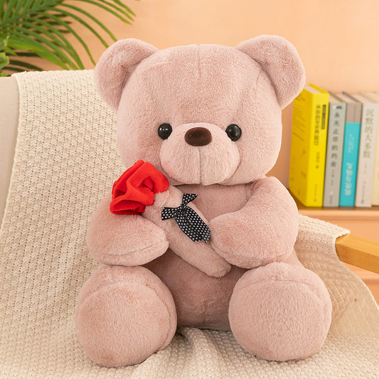 Teddy Bear with Rose – Soft plush bear with a rose, available in white, pink, brown, and gray, perfect for gifting on special occasions. Made with PP cotton and rabbit plush.
