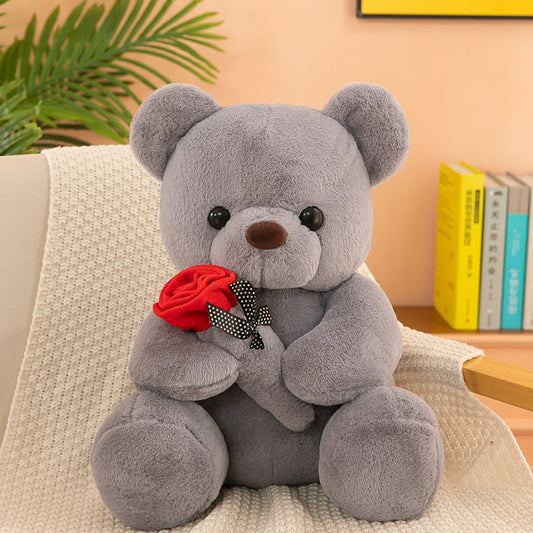 Teddy Bear with Rose – Soft plush bear with a rose, available in white, pink, brown, and gray, perfect for gifting on special occasions. Made with PP cotton and rabbit plush.