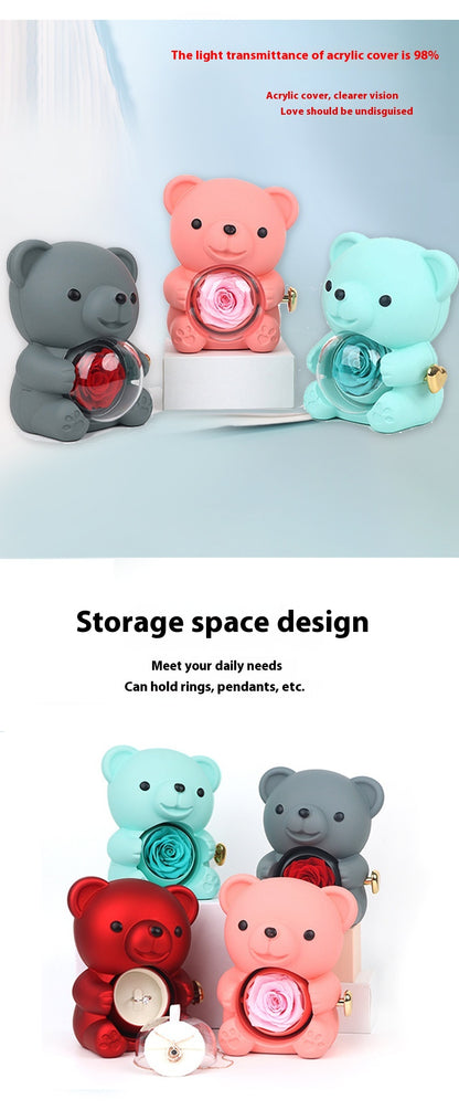 **Rotating Bear Gift Box – Playful & Elegant Packaging 🎁** A **plastic jewelry box** with a **rotating bear design** and **preserved plastic flowers**, perfect for gifting jewelry. Measures **12x13x15.5cm**. Adds charm to your special present! 🎉