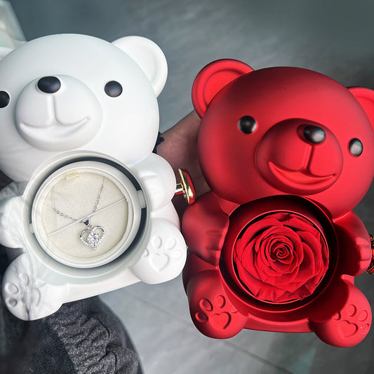 **Rotating Bear Gift Box – Playful & Elegant Packaging 🎁** A **plastic jewelry box** with a **rotating bear design** and **preserved plastic flowers**, perfect for gifting jewelry. Measures **12x13x15.5cm**. Adds charm to your special present! 🎉
