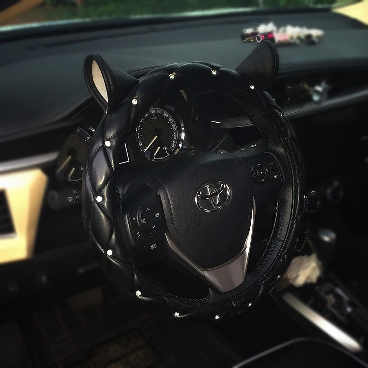 Super cute steering wheel cover made from environmentally friendly PU leather, embellished with high-quality rhinestones and a playful ear design. Suitable for all seasons and most steering wheels.