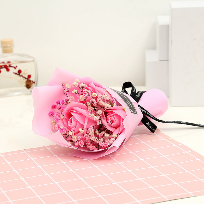 **"Elegant soap flower bouquet featuring delicate roses, forget-me-nots, and carnations, beautifully wrapped in premium paper with a gold ribbon. A timeless gift for weddings, birthdays, and special occasions."**