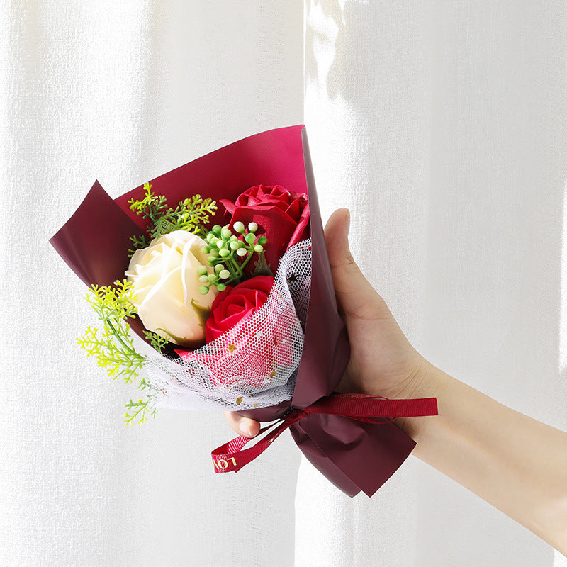 **"Elegant soap flower bouquet featuring delicate roses, forget-me-nots, and carnations, beautifully wrapped in premium paper with a gold ribbon. A timeless gift for weddings, birthdays, and special occasions."**