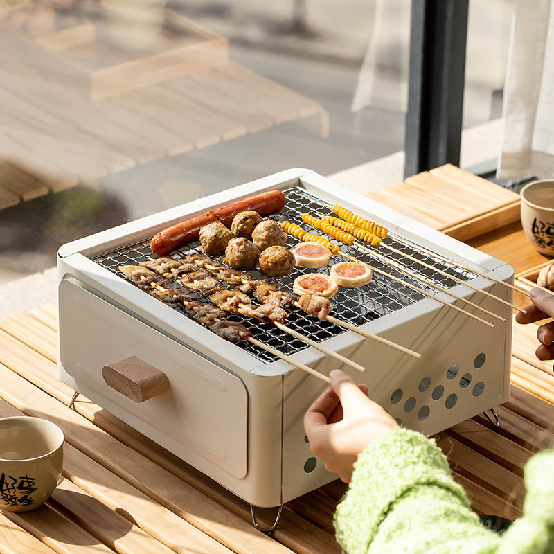 "Square Barbecue Oven-Grill – A white, alloy-constructed grill designed for 3-5 people, featuring a split-type structure, carbon fuel compatibility, and includes a charcoal plate and grill net. Perfect for outdoor gatherings and cookouts."