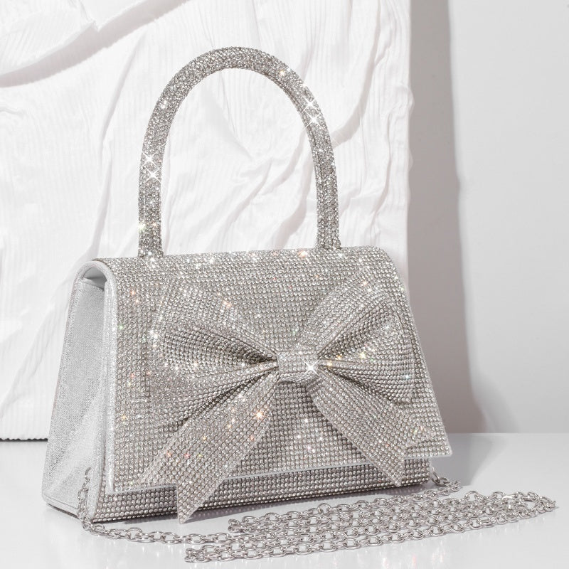 Step into the world of luxury and sophistication with the Elegant Full-Diamond Bow Handbag, a true statement piece that combines timeless elegance with a modern edge. Designed for the fashion-forward, this handbag is a stunning blend of street trend and light luxury style.