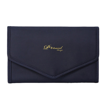 Elegant and portable navy blue travel jewelry bag with multiple compartments for organizing rings, necklaces, and earrings.
