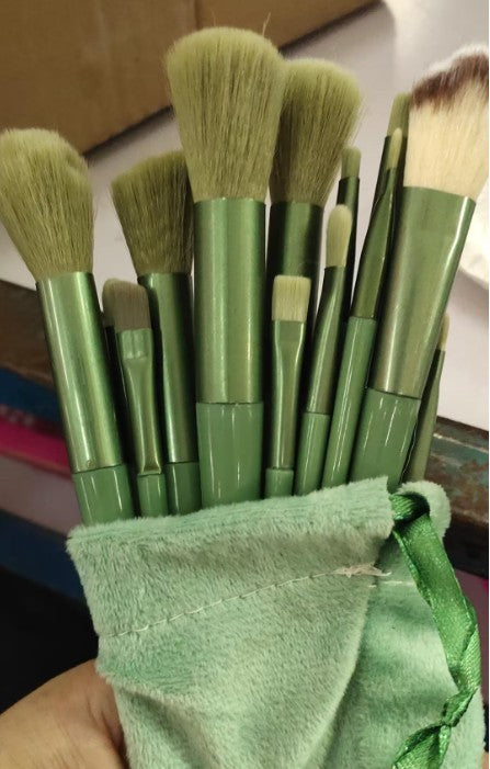 A 13-piece makeup brush set featuring soft synthetic bristles, durable plastic handles, and aluminum ferrules. The set includes brushes for foundation, powder, blush, highlighter, eyeshadow, lip, eyebrow, concealer, and blending. Available in various packaging options such as cloth bags and boxes in green, pink, and yellow. Ideal for professional and personal use, providing precise application and easy cleaning.
