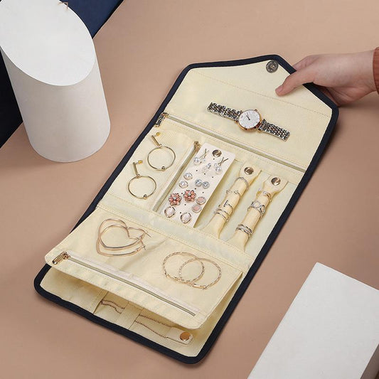 Elegant and portable navy blue travel jewelry bag with multiple compartments for organizing rings, necklaces, and earrings.
