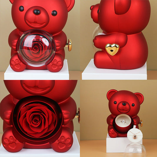 **Rotating Bear Gift Box – Playful & Elegant Packaging 🎁** A **plastic jewelry box** with a **rotating bear design** and **preserved plastic flowers**, perfect for gifting jewelry. Measures **12x13x15.5cm**. Adds charm to your special present! 🎉