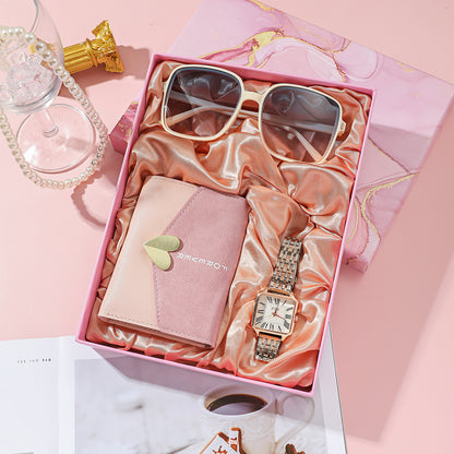 Elegant Women's Watch Business Gift Set featuring a sleek, fashion-forward design. This quartz movement timepiece is adorned with a stylish pointer and number display. The 35mm round dial with a spiral crown ensures precision, while the stainless steel needle buckle offers durability. The set includes a watch, glasses, wallet, and an elegant packaging box, making it a perfect gift choice. Available in square steel belt, pink belt, or white belt styles, this set is designed to impress, ideal for both busines