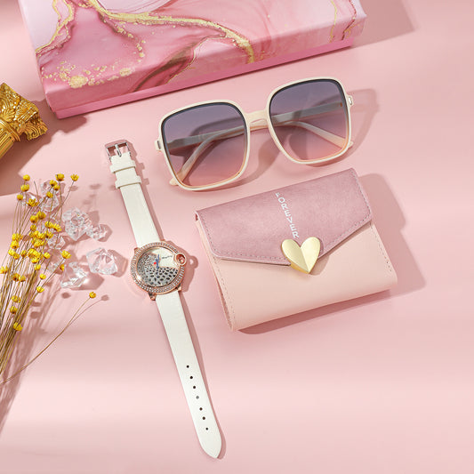 Elegant Women's Watch Business Gift Set featuring a sleek, fashion-forward design. This quartz movement timepiece is adorned with a stylish pointer and number display. The 35mm round dial with a spiral crown ensures precision, while the stainless steel needle buckle offers durability. The set includes a watch, glasses, wallet, and an elegant packaging box, making it a perfect gift choice. Available in square steel belt, pink belt, or white belt styles, this set is designed to impress, ideal for both busines
