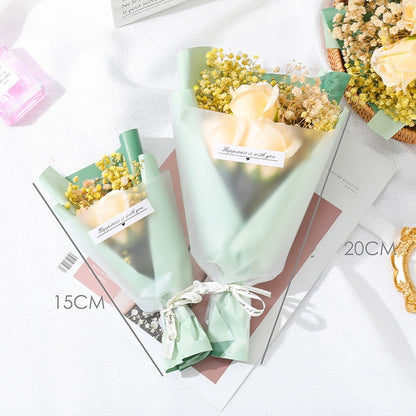 **"Elegant soap flower bouquet featuring delicate roses, forget-me-nots, and carnations, beautifully wrapped in premium paper with a gold ribbon. A timeless gift for weddings, birthdays, and special occasions."**
