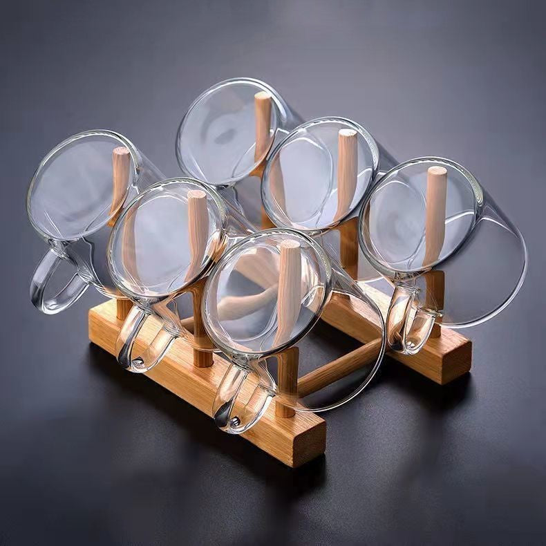 A beautifully arranged Thick Glass Transparent Tea Set, featuring a minimalist design with high borosilicate glass. The set includes six elegant tea cups and a matching cup holder, perfect for serving tea. Available in various sizes and styles, including transparent and colorful options with long spout pots.