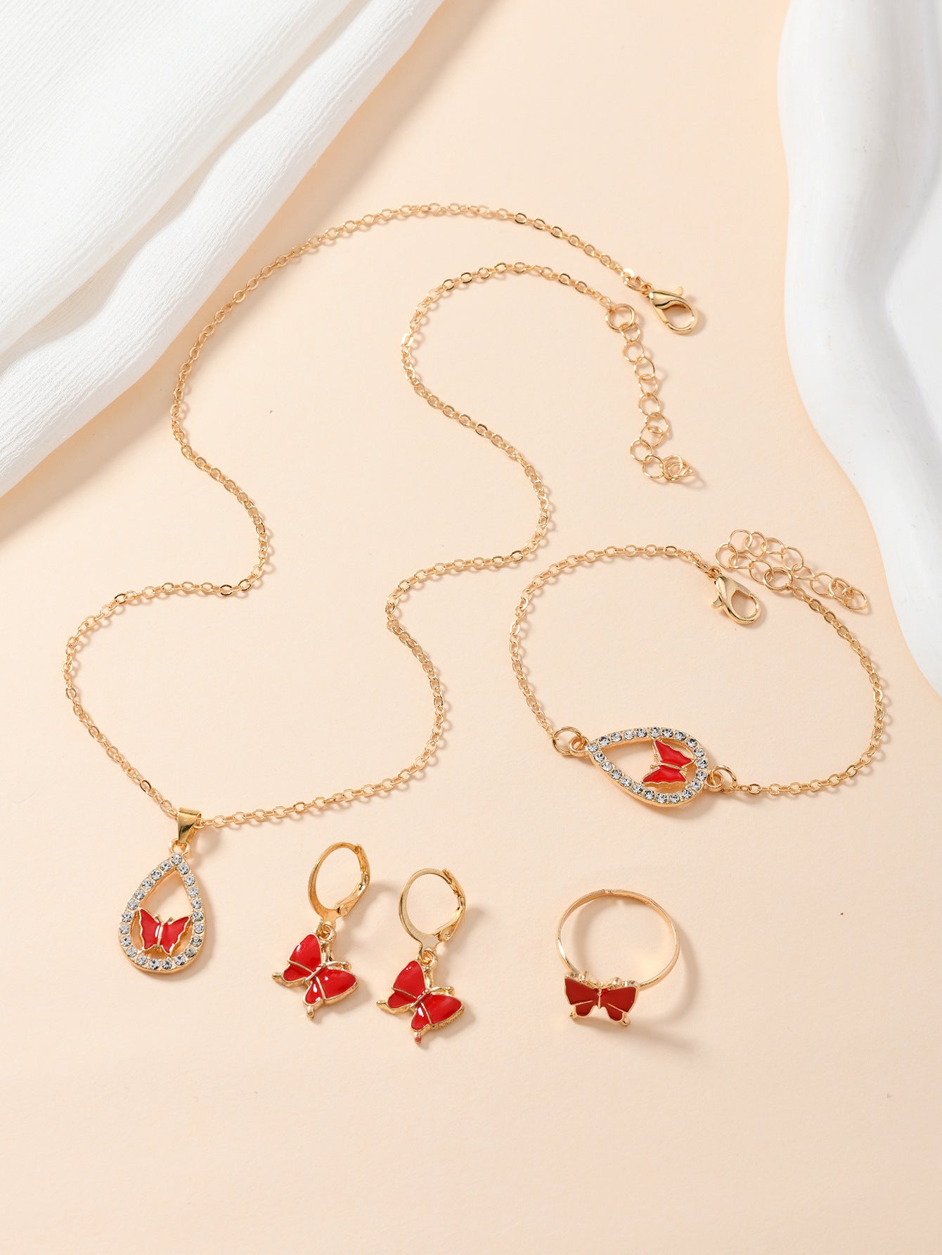 Elegant Butterfly Jewelry Set featuring a necklace, earrings, bracelet, and ring in electroplated alloy, available in red, pink, white, and black.