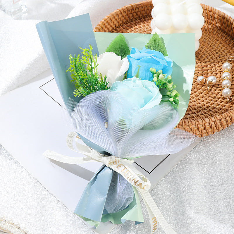 **"Elegant soap flower bouquet featuring delicate roses, forget-me-nots, and carnations, beautifully wrapped in premium paper with a gold ribbon. A timeless gift for weddings, birthdays, and special occasions."**