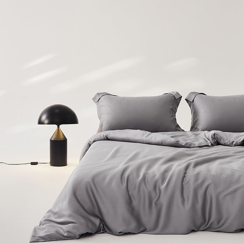 Luxuriously soft Four-Piece Ice Silk Bed Sheets made from breathable Lyocell fiber (Tencel). Features a modern minimalist design, reactive dyeing for long-lasting color, and a silky-smooth texture for year-round comfort. Available in multiple sizes.