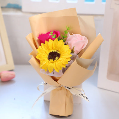 **"Elegant soap flower bouquet featuring delicate roses, forget-me-nots, and carnations, beautifully wrapped in premium paper with a gold ribbon. A timeless gift for weddings, birthdays, and special occasions."**