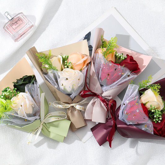**"Elegant soap flower bouquet featuring delicate roses, forget-me-nots, and carnations, beautifully wrapped in premium paper with a gold ribbon. A timeless gift for weddings, birthdays, and special occasions."**