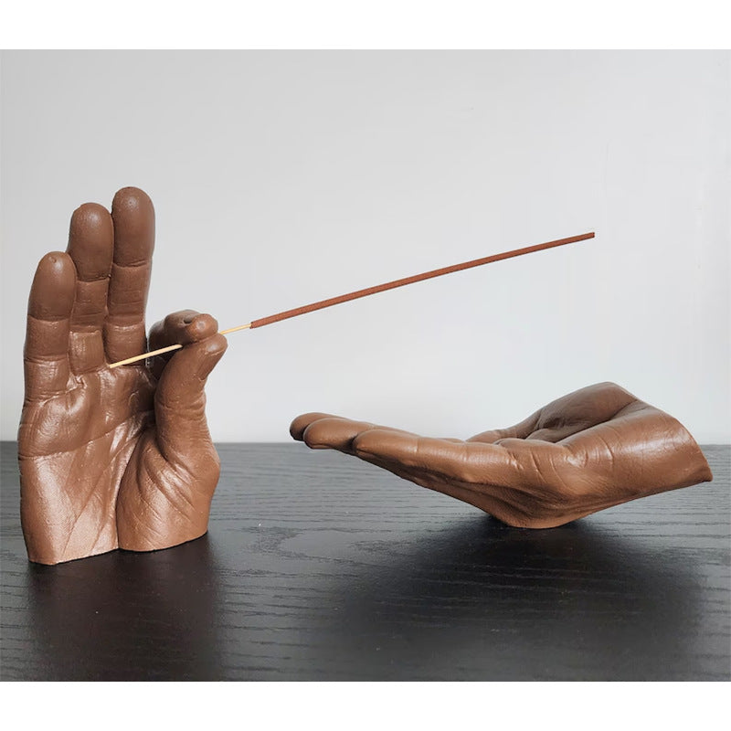 Cartoon-style resin incense holder in the shape of hands, available in black, white, light yellow, and brown. Made from synthetic resin, with a size of 19 * 10 * 10 cm, perfect for holding and receiving incense.