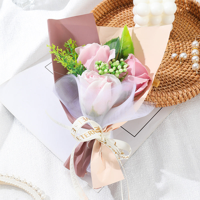 **"Elegant soap flower bouquet featuring delicate roses, forget-me-nots, and carnations, beautifully wrapped in premium paper with a gold ribbon. A timeless gift for weddings, birthdays, and special occasions."**