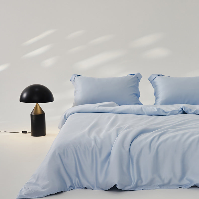 Luxuriously soft Four-Piece Ice Silk Bed Sheets made from breathable Lyocell fiber (Tencel). Features a modern minimalist design, reactive dyeing for long-lasting color, and a silky-smooth texture for year-round comfort. Available in multiple sizes.