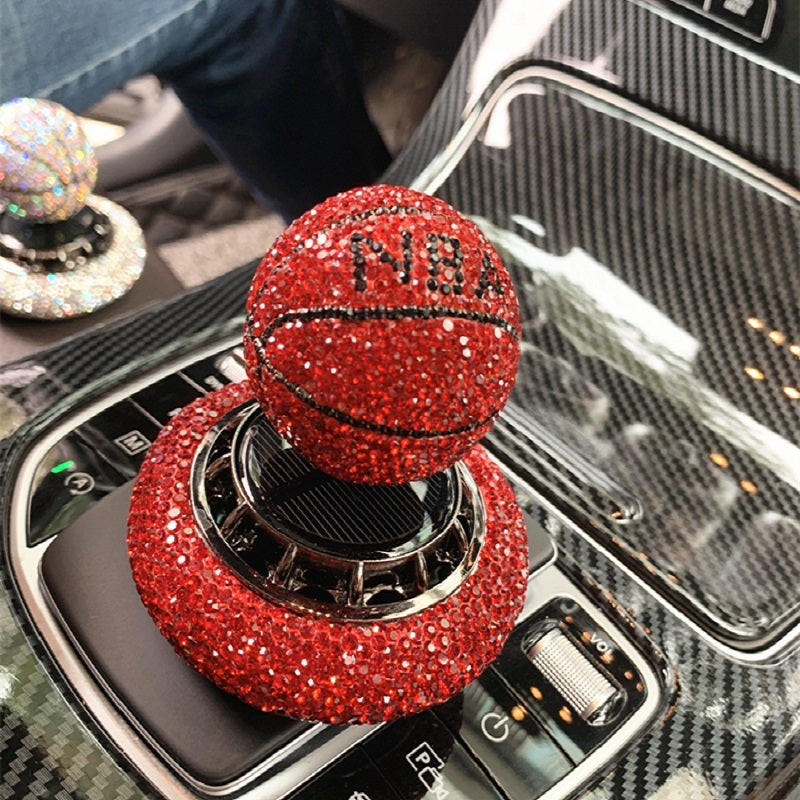 Solar-powered basketball ornament with diamond-encrusted design, rotating with sunlight. Includes solid aromatherapy for a pleasant fragrance. Available in red, white, and blue with a non-slip base.