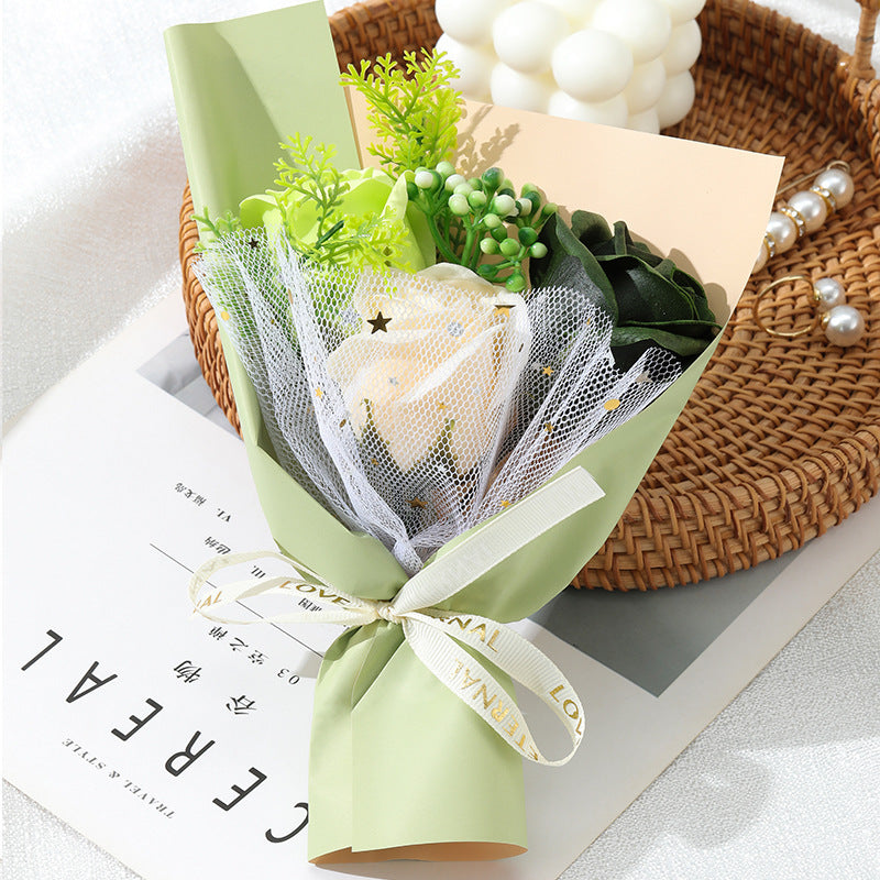 **"Elegant soap flower bouquet featuring delicate roses, forget-me-nots, and carnations, beautifully wrapped in premium paper with a gold ribbon. A timeless gift for weddings, birthdays, and special occasions."**