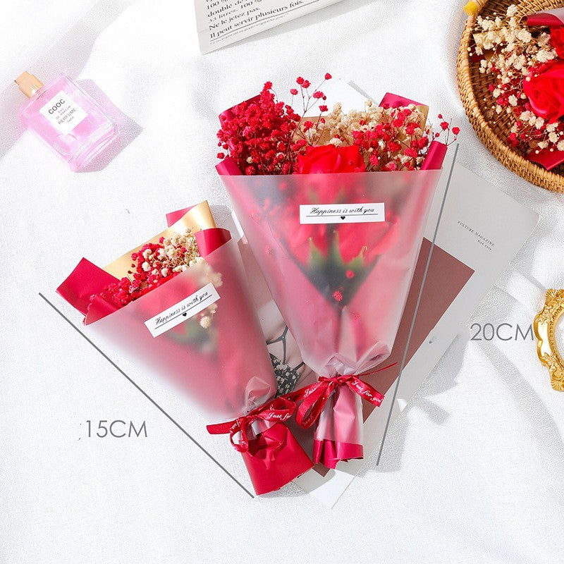 **"Elegant soap flower bouquet featuring delicate roses, forget-me-nots, and carnations, beautifully wrapped in premium paper with a gold ribbon. A timeless gift for weddings, birthdays, and special occasions."**